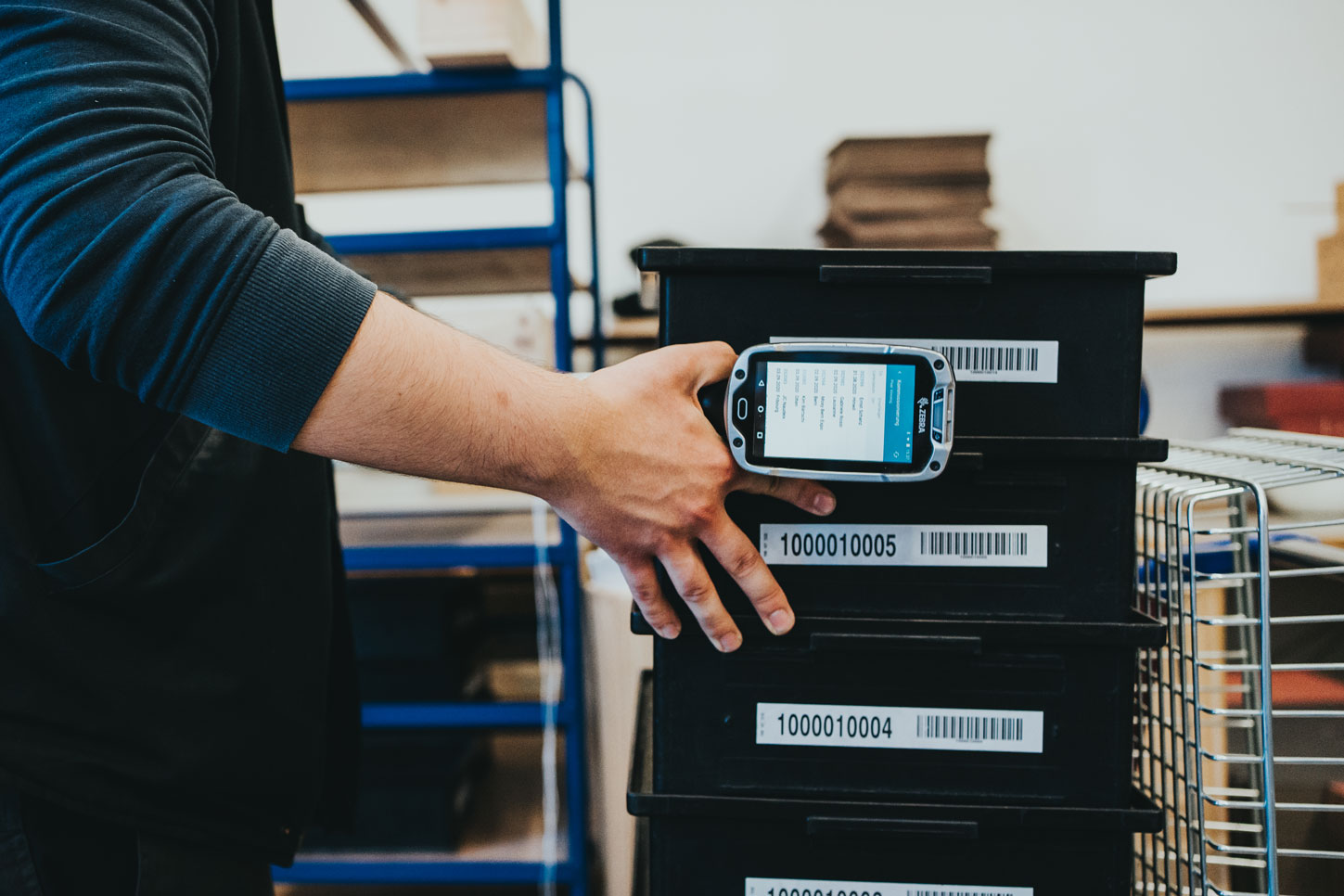 Lagermitarbeiter%20scannt%20beschriftete%20Lagerbeh%E4lter%20mit%20einem%20mobilen%20Barcodescanner.